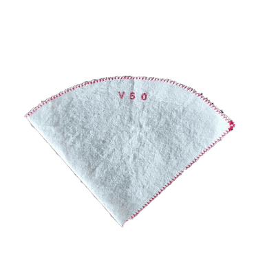 Filtro de pano branco em forma de cone, com borda vermelha e V60 bordado a vermelho no centro. Fundo em branco.